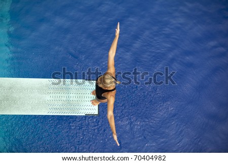 Girl standing on diving board, preparing to dive