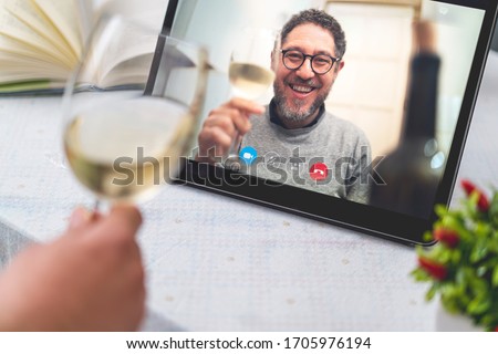 Best friends drinking and toasting online on a video call during the quarantine lockdown. Stay safe at home lifestyle concept.