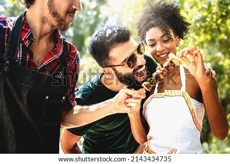 Multiethnic Joyful young people joking outdoors at barbecue eating meat skewers and having fun carefree together - Friends carefree on weekend grilling together in thecountryside Foto stock © 
