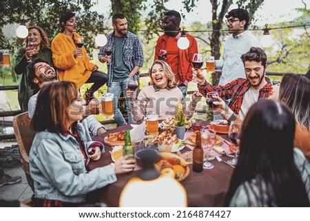 Young friends having fun drinking beer and wine on balcony at farmhouse dinner pic nic party - Hipster millennial people eating bbq food at fancy restaurant together - Dinning life style concept Foto stock © 