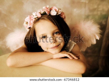 Beautiful young girl wearing angel wings and floral halo