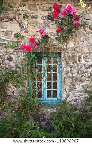 stone cottage in Brittany with window and climbing roses