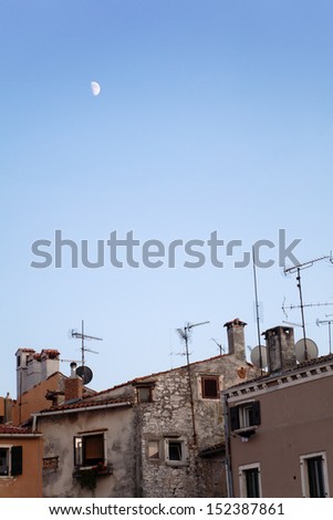 old houses with antennas and a blue sky with the moon in Rovinj, Croatia