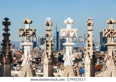 view of the Milan skyline through architectural details of the Milan Cathedral with focus on the background