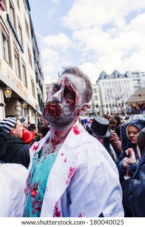 COLOGNE, GERMANY - MARCH 03: unidentified people and a man with a painted horror mask at the Rose Monday parade on March 03, 2014 in Cologne. The parade is the largest one in Germany.