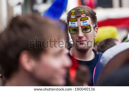 COLOGNE, GERMANY - MARCH 03: unidentified people with a man with unique glasses at the Rose Monday parade on March 03, 2014 in Cologne. The parade is the largest one in Germany.