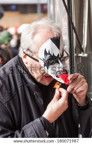 COLOGNE, GERMANY - MARCH 03: funny picture of an unidentified man with mask eating at the Rose Monday parade on March 03, 2014. The famous parade from Cologne is the German largest one.