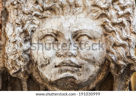 antique face sculpture at a wall in Verona, Italy