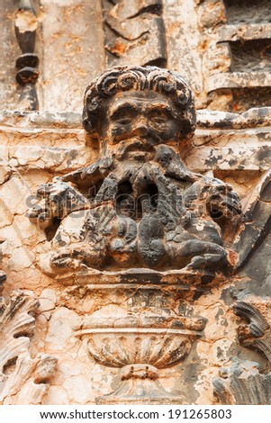 antique face sculpture on a wall in the old town of Verona, Italy