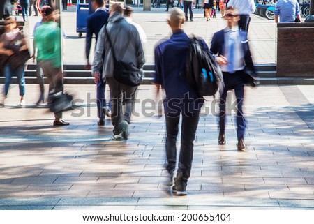 commuters in motion blur walking in a pedestrian area