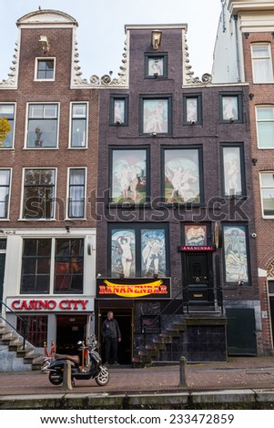 AMSTERDAM, NETHERLANDS - NOVEMBER 13: red light district with unidentified people on November 13, 2014 in Amsterdam. The district is world reknown and a famous attraction for tourists.