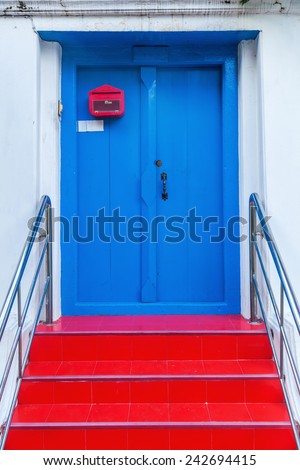 old blue door with red stairs in the city of Bangkok, Thailand