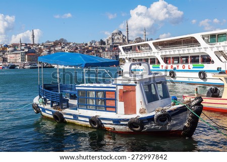 ISTANBUL, TURKEY - APRIL 11, 2015: fishing boat and ferry on the Golden Horn with view to the old town with Sueleymaniye mosque. Istanbul is the largest city in Turkey and a famous travel destination