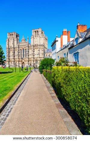 WELLS, ENGLAND - JUNE 30, 2015: Wells Cathedral with unidentified people is a Church of England in Wells, Somerset, dedicated to St Andrew the Apostle, and is the seat of the Bishop of Bath and Wells