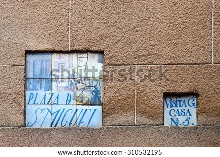 MADRID, SPAIN - MARCH 17, 2015: artistic street sign in Madrid. It\'s a uniqueness that the street signs in Madrid are made from tiles hand painted with different subjects by Spanish artists
