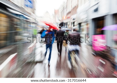 city scene with a crowd of people on a rainy day with zoom effect made by camera