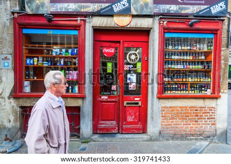 GHENT, BELGIUM - SEPTEMBER 02, 2015: old beverage shop in the old town of Ghent with unidentified man. With about 240,000 Ghent is Belgiums 2nd largest municipality by number of inhabitants