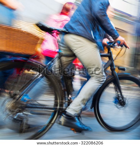 abstract motion blur picture of a person pushing a bicycle in the pedestrian area of a city