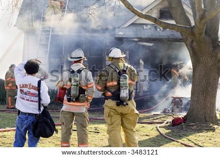 Firefighters and Photographer at a House Fire while it is burning