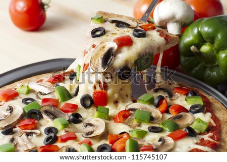 Image of a melted pizza on a stainless pan over the wooden table