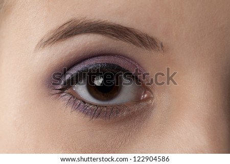 Close-up image of a woman\'s right eye with eye shadow