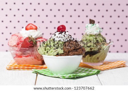 Three flavors of ice cream on the bowl with different toppings