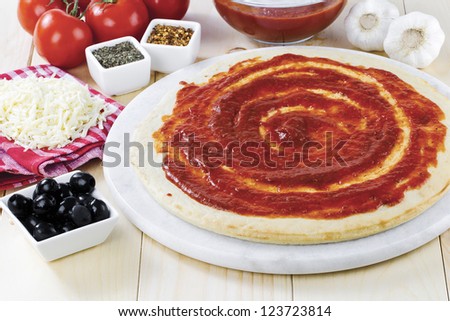 Close-up shot of pizza dough with other pizza ingredients.