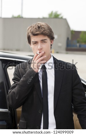 Young man in suit smoking a cigarette