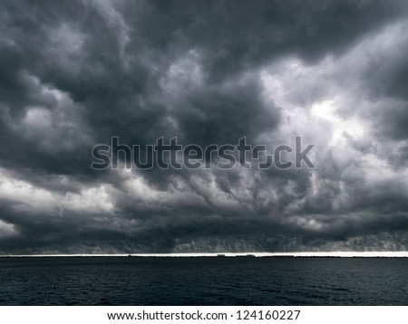 Storm clouds gather ominously above the ocean