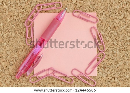 Close-up image of a blank pink paper with ballpen and paper clip