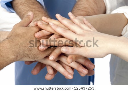 A diverse group of businesspersons with their hands together in form of teamwork and unity