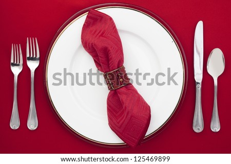 Overhead shot of dinner table setting on red table cloth.