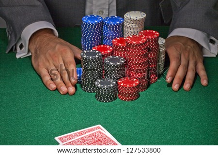 Human hands taking a big stack of gambling chips
