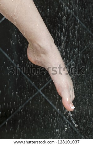 Close up image of female washing her foot on shower