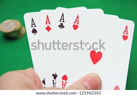 hand with poker of aces on a table game