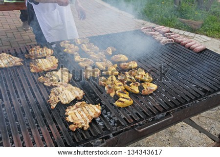 restaurant cook while cooking chicken breasts cooked in a giant barbecue