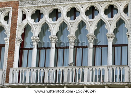 ancient balcony in Venetian style with arched windows of a residence in Venice