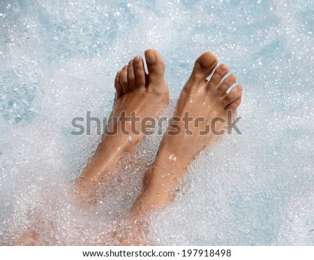 Two beautiful women's feet in the jacuzzi to facilitate venous circulation