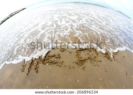 sea wave clears the words THE END on the beach photographed with fisheye lens 2