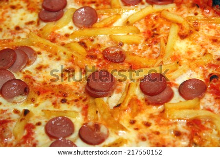 Tasty Pizza cooked on a wood-burning oven with French fries and sausage