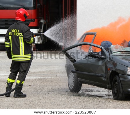 brave firefighter with helmet off the car burned with the foam