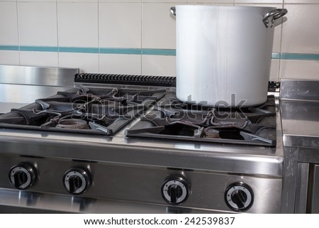 large aluminum pot over the stove's gas stainless steel industrial kitchen