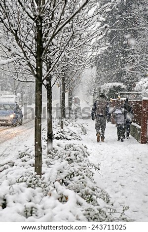family walks in the city  sidewalk during a winter snowfall
