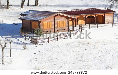 lovely wooden chalet in the mountains and snowy all around in winter