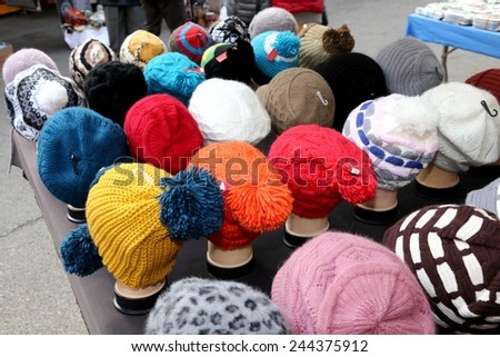 caps of all sizes for sale in stand of outdoor flea market