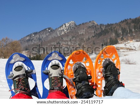 husband and wife on vacation with snowshoes in the mountain