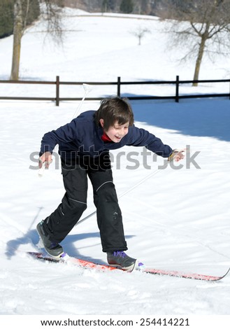young boy for first time with cross-country skis on fresh snow falls in winter
