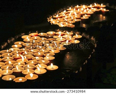 many lit candles at mass in church