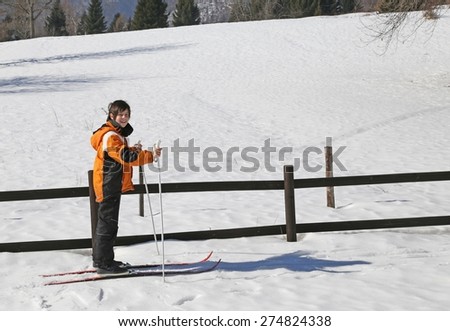 pretty young boy goes on cross-country skiing on the white snow in the mountains in winter
