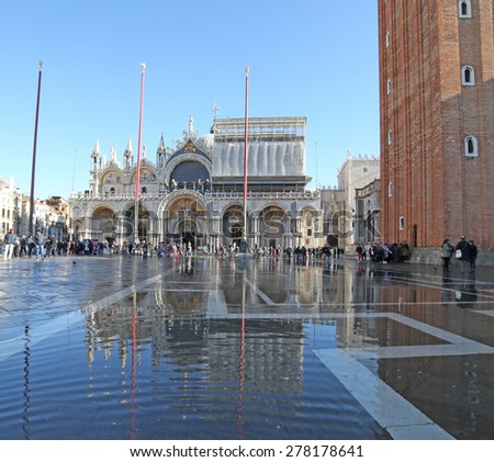 VENICE, VE, ITALY - January 31, 2015: Saint Mark\'s Basilica during high tide  with tourists and water in st. mark\'s square